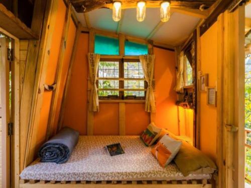 a bedroom in a tiny house with a window at Zostel Plus Mussoorie- Kempty in Mussoorie