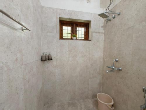 a bathroom with a shower with a window at Casa Perla by Eco Escape Hub in Trivandrum