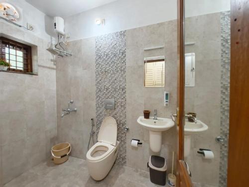 a bathroom with a toilet and a sink at Casa Perla by Eco Escape Hub in Trivandrum