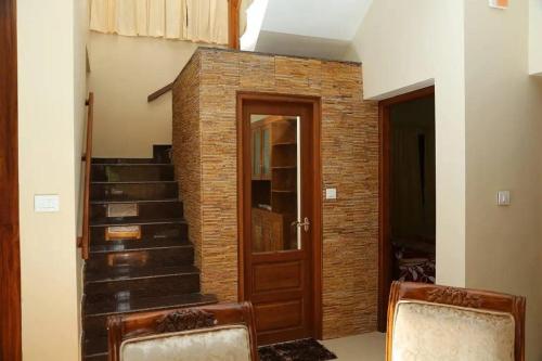 a room with a staircase and a brick wall at Casa Perla by Eco Escape Hub in Trivandrum