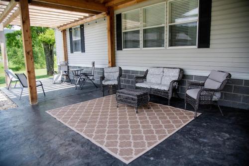 a porch with chairs and a table and a rug at Countryside Living with a great outdoor space in Grant