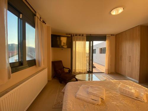 a bedroom with a bed and a chair and a window at EUPHORIA Pool Villa in Porto Rafti