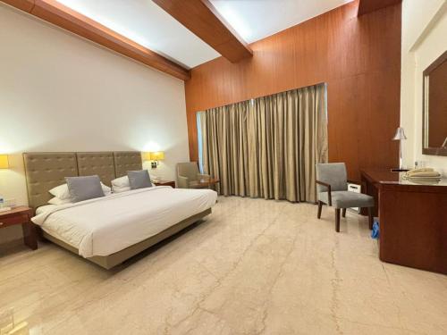 Schlafzimmer mit einem Bett, einem Schreibtisch und einem Stuhl in der Unterkunft The Hans, New Delhi in Neu-Delhi