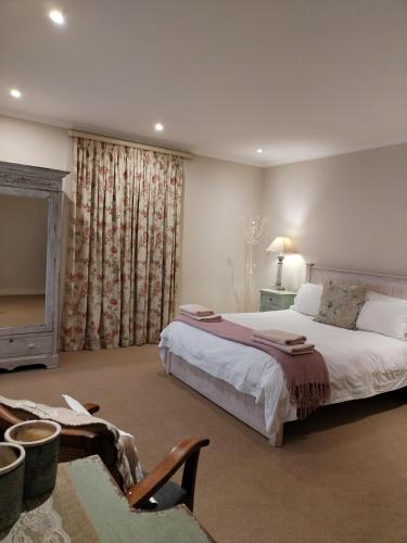 a bedroom with a large bed and a fireplace at The Glades Cottage in Balgowan
