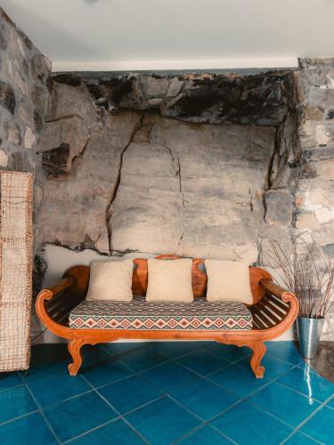 a couch sitting in a room with a stone wall at Hotel Belair in Sorrento