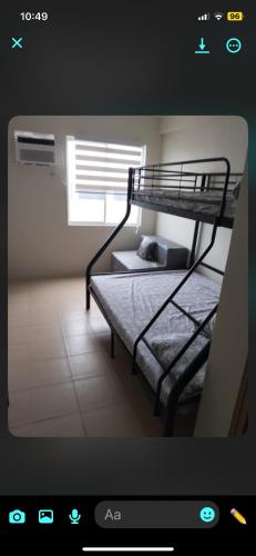 LagunaにあるRics Remarkable and Radiant Home in Dumaguete City - Marina Spatial B842の二段ベッド2台と窓のある寝室