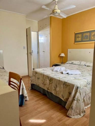 a bedroom with a bed and a table with a lamp at HOTEL LOS TILOS RECONQUISTA in Reconquista