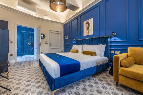 a blue bedroom with a bed and a chair at Maison Medina Malta in Mdina
