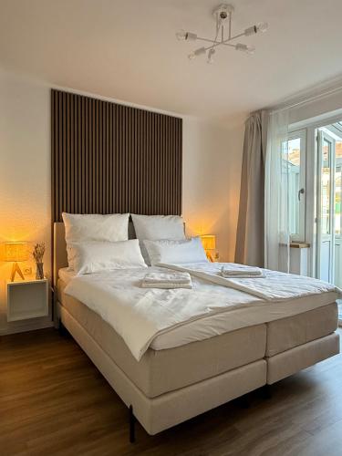 Un dormitorio con una gran cama blanca con dos lámparas. en Moderne 3 Zimmer Whg Zentrumsnähe 5 Personen, en Bremen