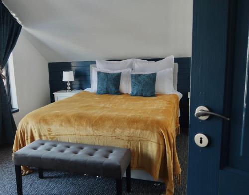 a bedroom with a king sized bed with blue pillows at Vama Buzaului Hillside Barn - camere la munte in Buzoel
