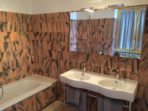 une salle de bain avec un lavabo, une baignoire et un miroir dans l'établissement Villa La Lézardière, à Bandol