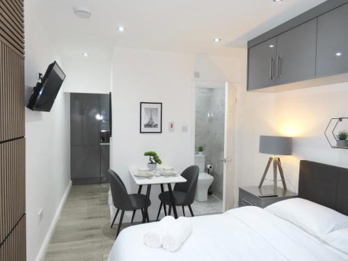 a bedroom with a bed and a table and chairs at 6 Mins to NEC & BHX Apartment with FREE Parking in Sheldon
