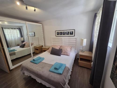sypialnia z łóżkiem, na którym leżą dwa niebieskie ręczniki w obiekcie Coqueto piso con Billar en Benalmadena Costa w mieście Benalmádena
