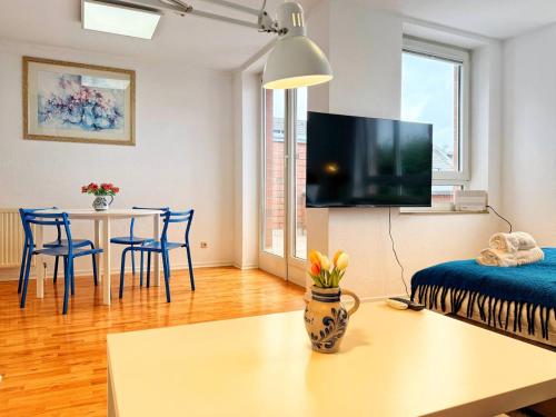 a living room with a table and a tv at Stilvolle Maisonette in Neuss - Balkon & Gratis-Parkplatz in Neuss