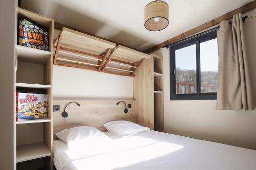 a bedroom with two beds and a window at Camping Le Florenville in Florenville