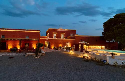 a building with a pool in the middle of a courtyard at Antica Masseria le Monache in Grottaglie