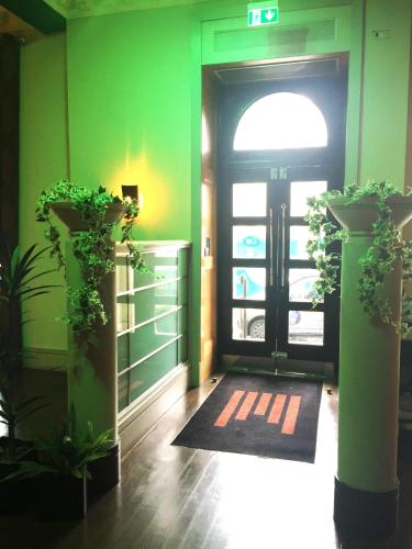 une porte d'entrée avec des plantes en pot devant dans l'établissement Millennium Hotel Glasgow, à Glasgow