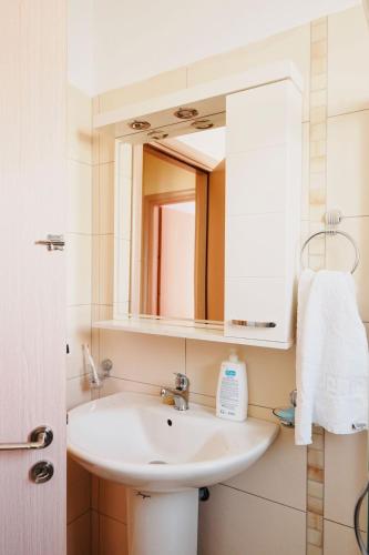 サランダにあるBlue Point Apartamentの洗面台と鏡のある浴室