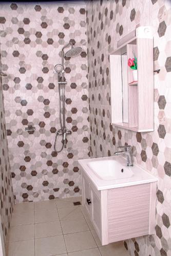 a bathroom with a white sink and a shower at Kindow Appart in Pointe-Noire