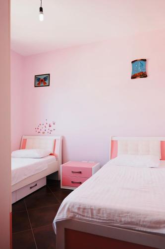 サランダにあるBlue Point Apartamentの白い壁の部屋にベッドが2つ