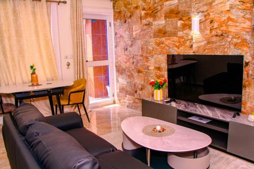 a living room with a couch and a large tv at Kindow Appart in Pointe-Noire