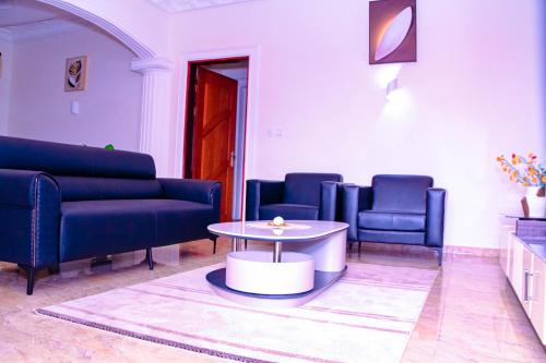 a living room with blue couches and a table at Kindow Appart in Pointe-Noire