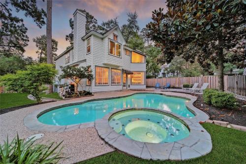 a home with a swimming pool in the yard at The Woodlands Gem with Pool and Spa in The Woodlands