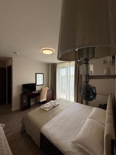 a bedroom with a large bed and a desk at Hotel Mondial - Eforie Nord in Eforie Nord