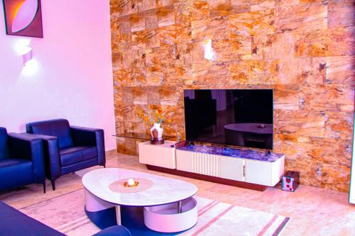 a living room with a tv and a couch and a table at Kindow Appart in Pointe-Noire