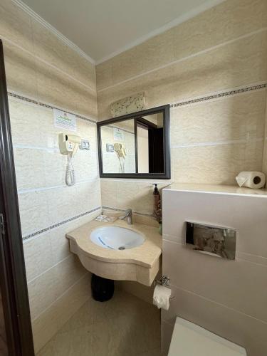 a bathroom with a sink and a mirror at Hotel Mondial - Eforie Nord in Eforie Nord