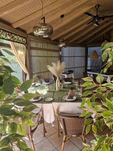a dining room with a table and chairs and plants at Vila Dincic doo in Veliko Gradište