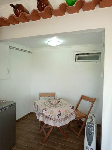 a table and chairs in a room with a table and a refrigerator at casinha do moleiro in Aveiras de Cima