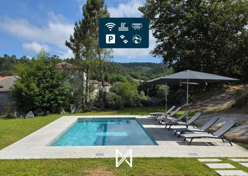 a swimming pool with chairs and an umbrella and a sign at MyStay - Encosta da Barragem in Fafe