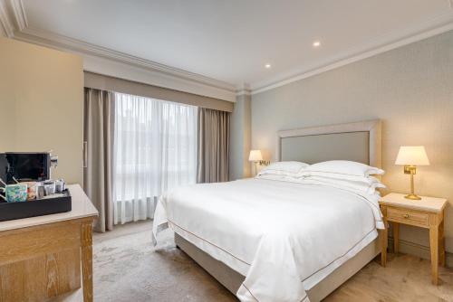 a bedroom with a white bed and a television at Brooks Hotel in Dublin