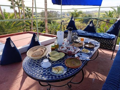 a blue table with food on top of a balcony at daryemma2 in Asilah