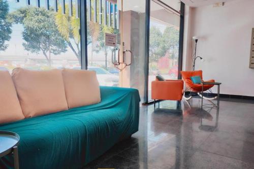 a living room with a green couch and chairs at BR Parklands Hotel in Klang