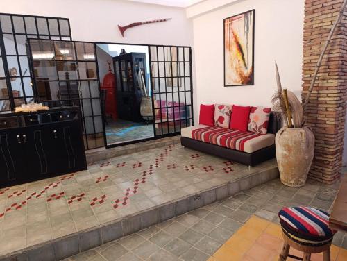a living room with a couch and flowers on the floor at daryemma2 in Asilah