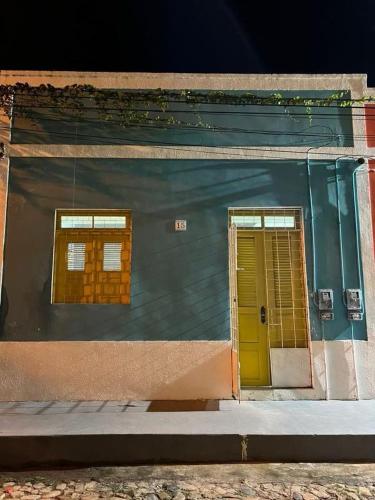 a building with two windows and a yellow door at Casa Zuilas in São Luís