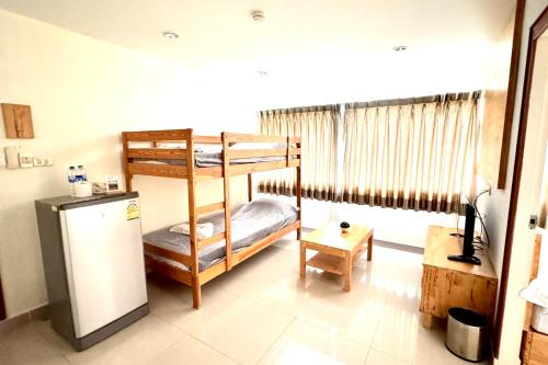 a room with two bunk beds and a refrigerator at L'Hotel Bangkok in Bangkok