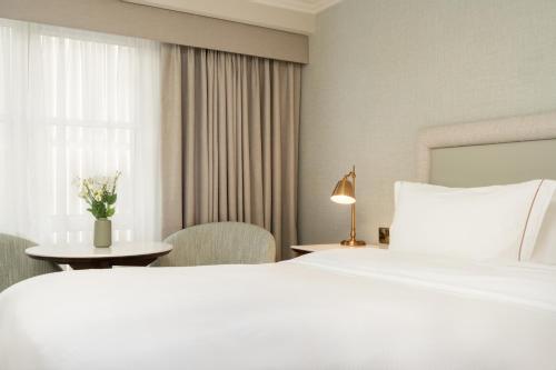 a hotel room with a large white bed and a table at Brooks Hotel in Dublin