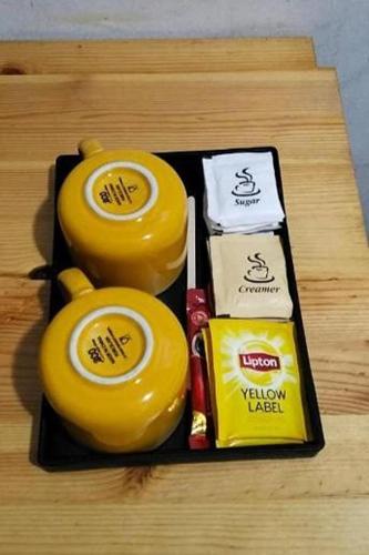 a tray with two yellow jars of food on a table at BR Parklands Hotel in Klang