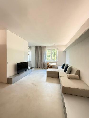 a large living room with a couch and a tv at Central & Modern Apartment in Banská Bystrica