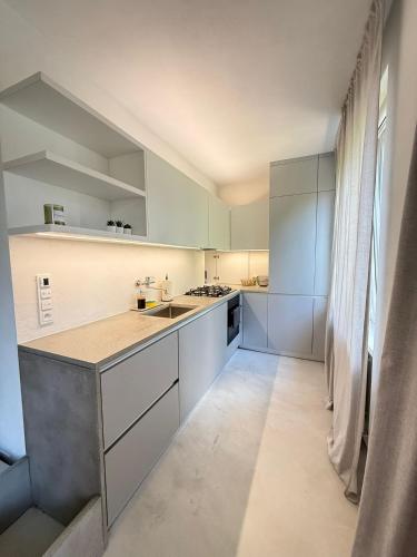 a kitchen with white cabinets and a large window at Central & Modern Apartment in Banská Bystrica