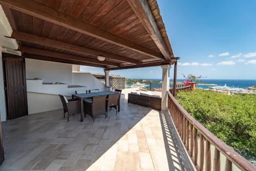 a patio with a table and chairs and the ocean at Villetta nel cuore di Porto Cervo in Porto Cervo