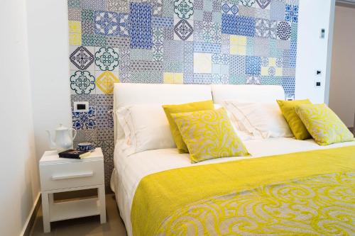 a bedroom with a bed with a yellow and blue patterned wall at Sciccosa Guest House in Taormina