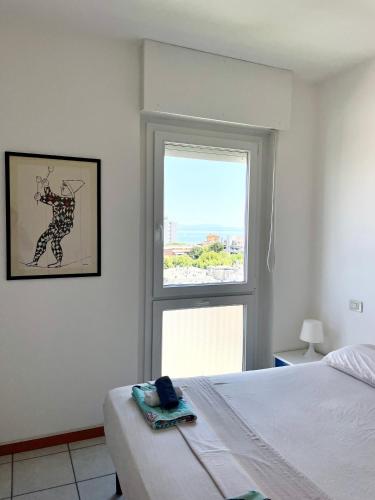 a bedroom with a bed and a window at Condominio Cam 78 in Lignano Sabbiadoro