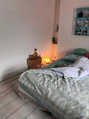 a bedroom with a bed and a table with a lamp at Cornish Cottage in Newquay