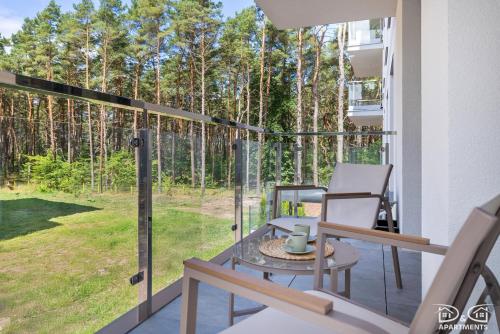 Un patio con una mesa y sillas en un balcón. en Apartament Pelikan D&D Apartments, en Międzywodzie