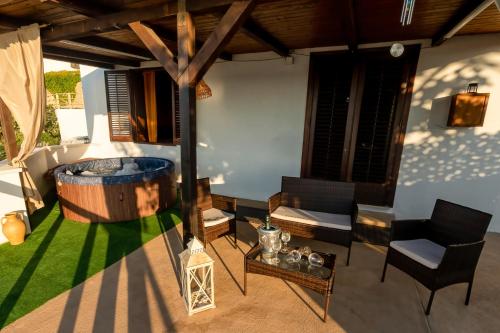 an outdoor patio with a hot tub and chairs at Baia Marina Suite with private jacuzzi in Balestrate