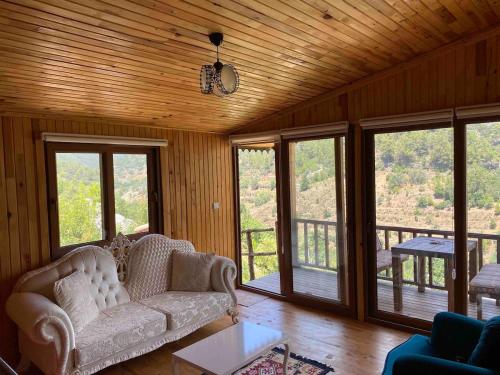 a living room with a couch and some windows at Hergül Holiday Village in Gazipasa